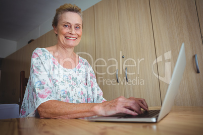 Smiling senior woman using a laptop