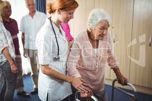 Nurse helping a retired woman to walk
