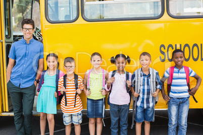 Portrait of smiling teacher and kids standing together