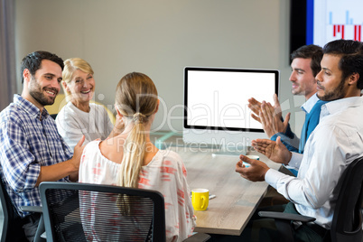 Coworkers applauding a colleague during a video conference