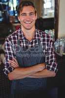 Smiling waiter with arms crossed