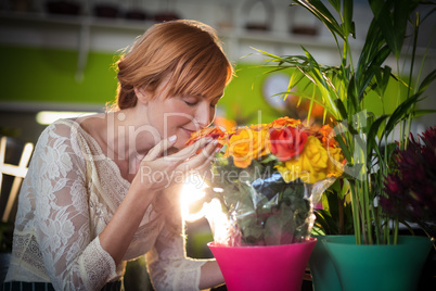 Female florist smelling rose flowers