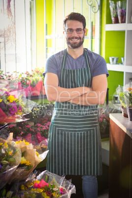 Male florist with arms crossed at his flower shop