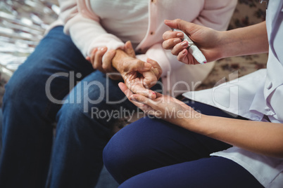 Nurse helping senior woman with diabetes