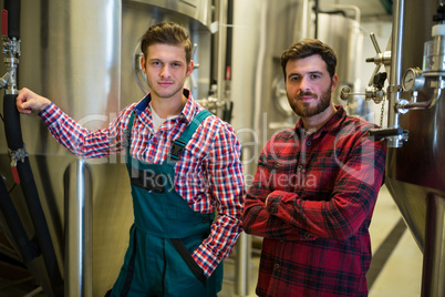 Brewers with arms crossed at brewery