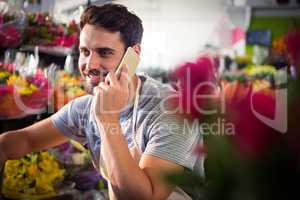 Male florist talking on mobile phone