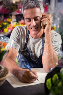 Male florist taking order on mobile phone