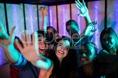 Group of smiling friends dancing on dance floor