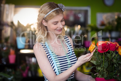 Female florist touching rose flowers