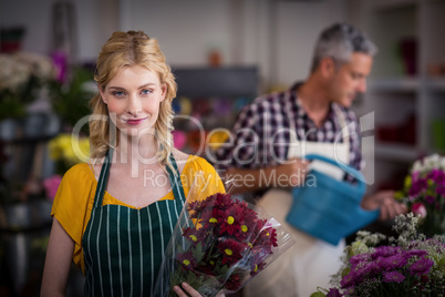 Happy female florist holding flower bouquet