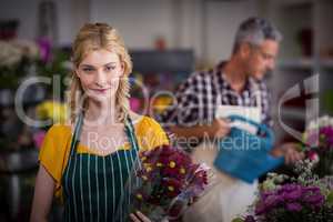 Happy female florist holding flower bouquet