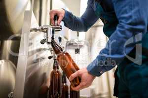 Brewer filling beer in bottle