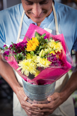 Male florist smelling flower