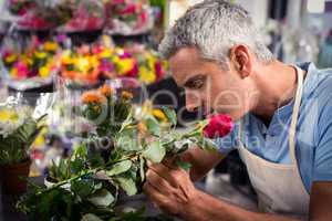 Male florist trimming stems of flowers at flower shop