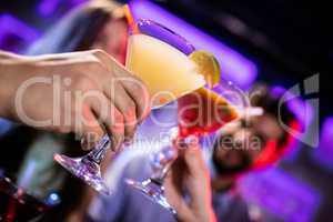 Friends toasting cocktail at bar counter