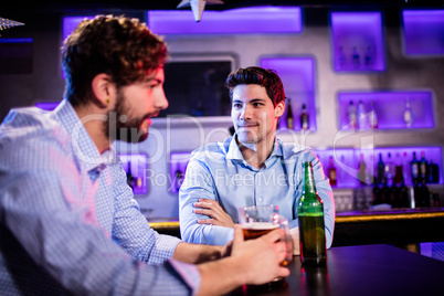 Friends sitting at bar counter and having beer