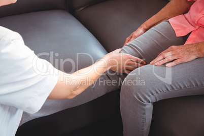 Nurse giving leg massage to senior woman