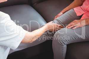 Nurse giving leg massage to senior woman