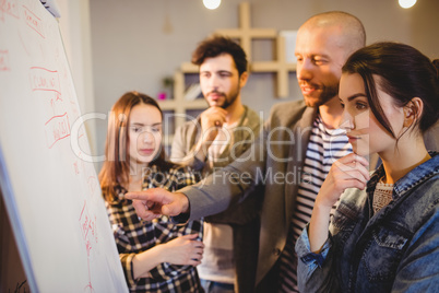 Team of graphic designer discussing chart on white board