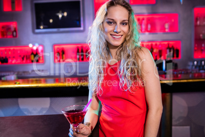 Portrait of beautiful woman holding cocktail glass