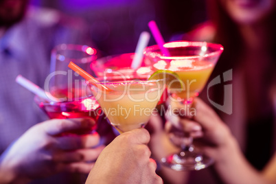 Group of friends toasting cocktail at bar counter