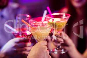 Group of friends toasting cocktail at bar counter