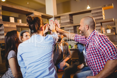 Colleagues giving high five at office