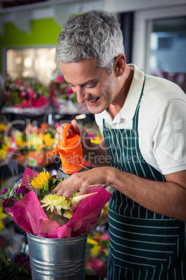 Male florist watering flowers with watering can