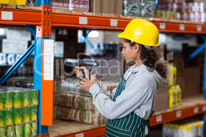 Female worker wearing yellow helmet scanning documents