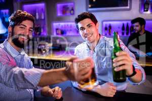 Portrait of men showing glass of beer and beer bottle