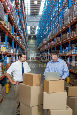 Managers working with a laptop put on a cardboard box