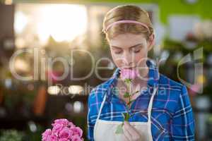 Female florist smelling pink rose