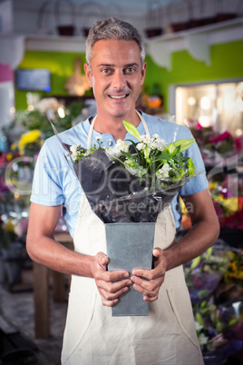 Male florist holding bouquet of flower at flower shop