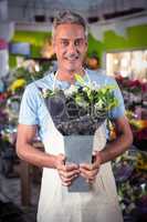 Male florist holding bouquet of flower at flower shop