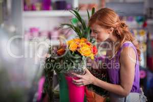 Female florist smelling flower bouquet