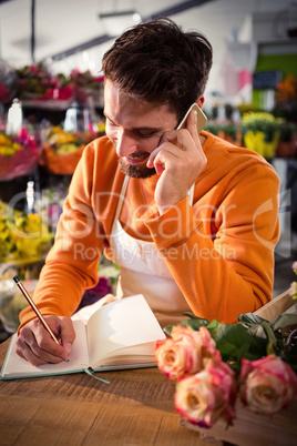 Male florist taking order on mobile phone