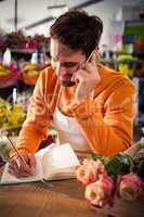 Male florist taking order on mobile phone