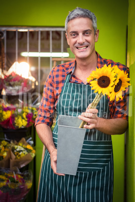 Male florist holding flower vase at flower shop