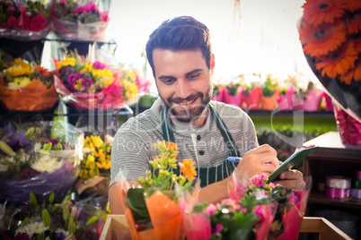 Male florist writing and making notes