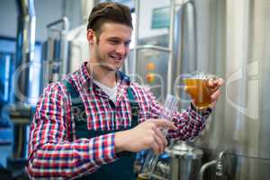 Brewer pouring beer in hydrometer cylinder