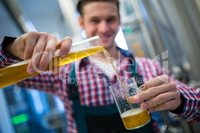 Brewer pouring beer in glass
