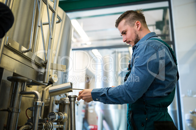 Brewer checking beer at brewery