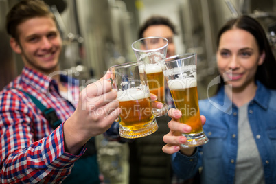 Brewers toasting beers at brewery factory