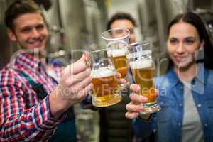 Brewers toasting beers at brewery factory