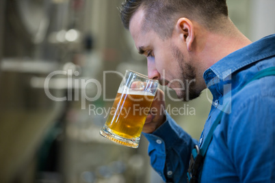 Close-up of brewer testing beer