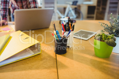 Pen holder with pens and file on table