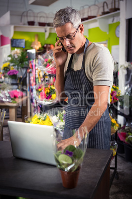 Male florist taking order on laptop