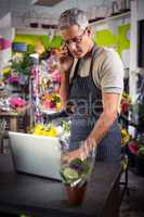 Male florist taking order on laptop