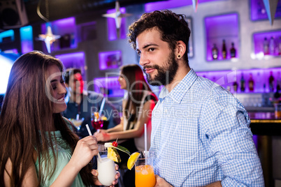 Smiling friends having cocktail at bar counter