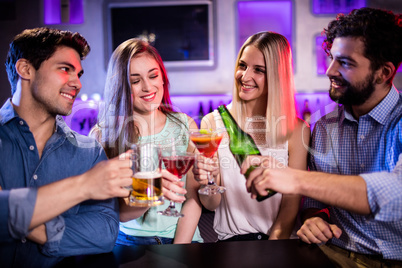 Group of friends toasting cocktail, beer bottle and beer glass a